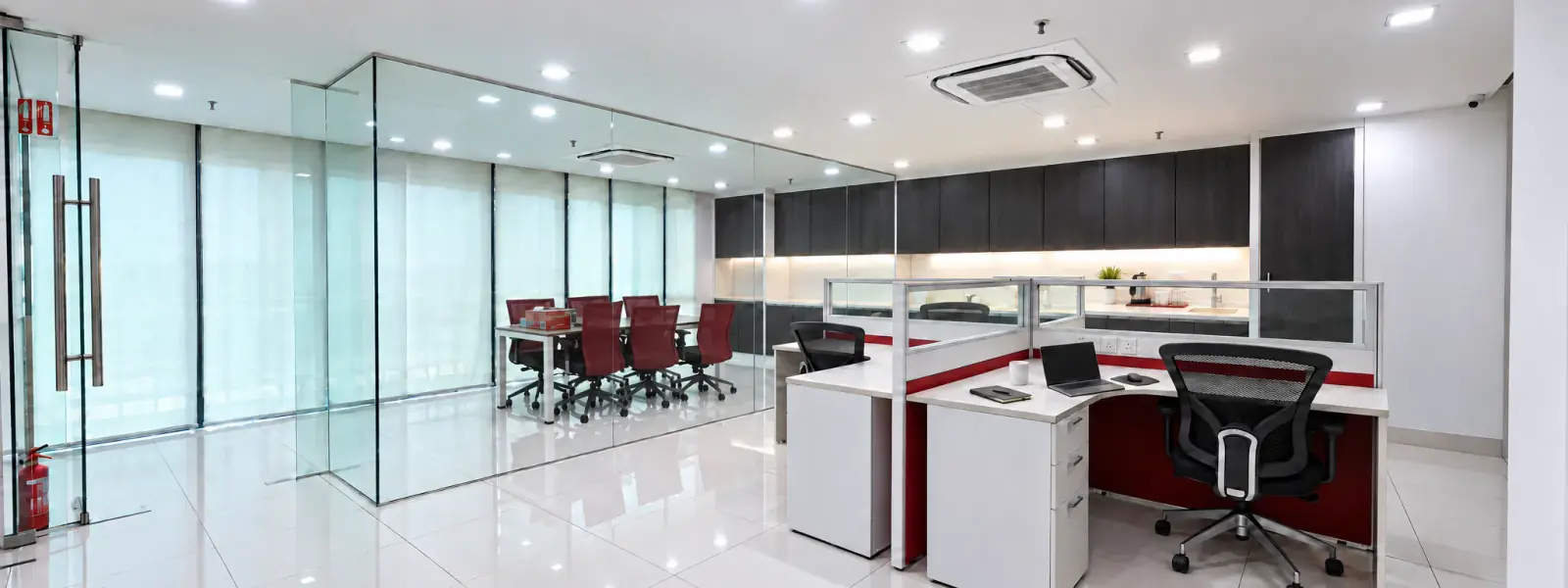Inside the LABÉAU office: a glass-walled meeting room with red chairs beside open workstations